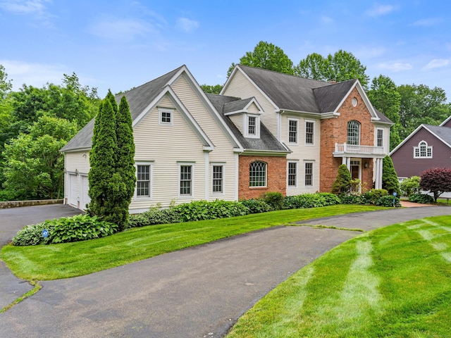 9 Autumn Leaves Rd, Wallingford, CT 06492 - view of front facade with driveway, brick siding, a front yard, roof with shingles, and an attached garage