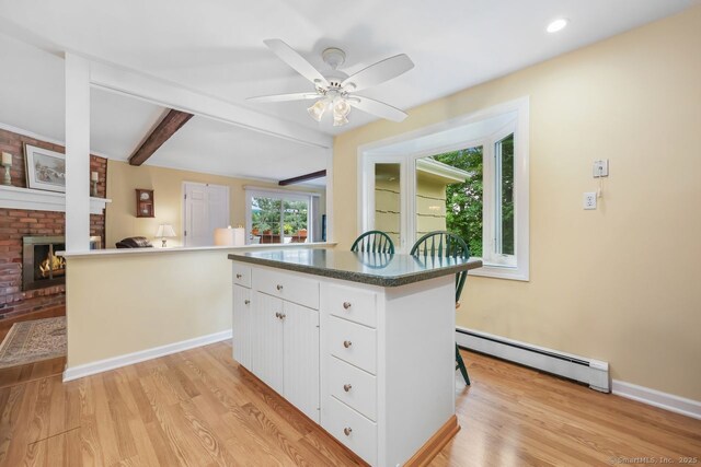 33 Raven Rd, Trumbull, CT 06611 - kitchen featuring a baseboard radiator, light wood-style floors, a kitchen island, white cabinets, and beamed ceiling