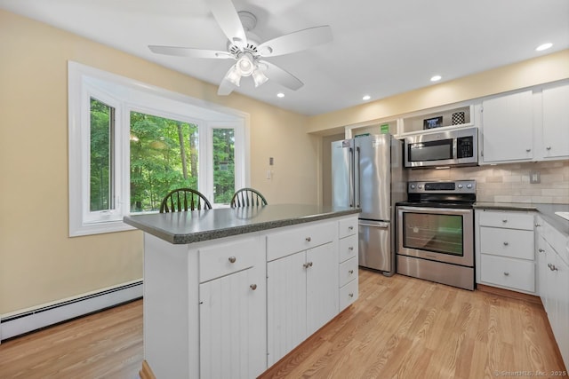 33 Raven Rd, Trumbull, CT 06611 - kitchen featuring stainless steel appliances, a baseboard radiator, light wood finished floors, a kitchen island, and white cabinetry