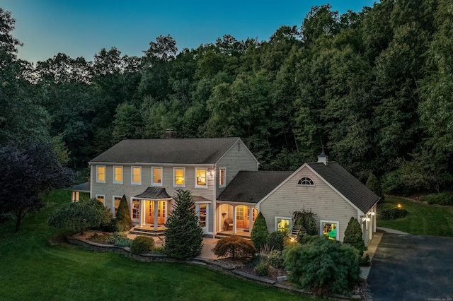 607 Tolland Stage Rd, Tolland, CT 06084 - colonial inspired home featuring a front lawn, driveway, a chimney, and a view of trees