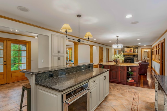 607 Tolland Stage Rd, Tolland, CT 06084 - kitchen with a center island, stainless steel oven, recessed lighting, ornate columns, and ornamental molding