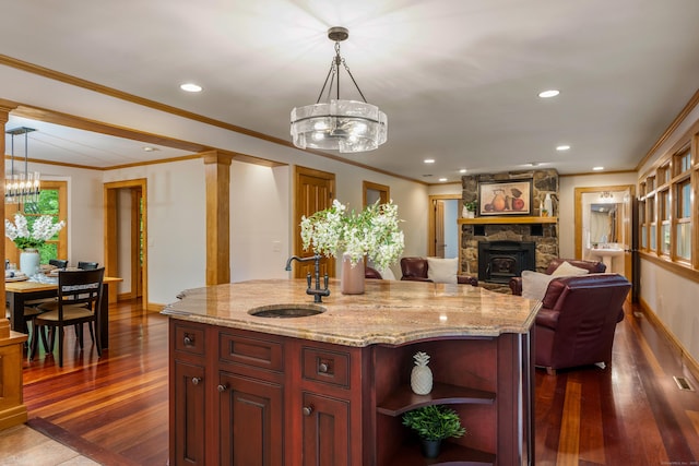 607 Tolland Stage Rd, Tolland, CT 06084 - kitchen with a sink, a chandelier, dark wood-style floors, reddish brown cabinets, and hanging light fixtures