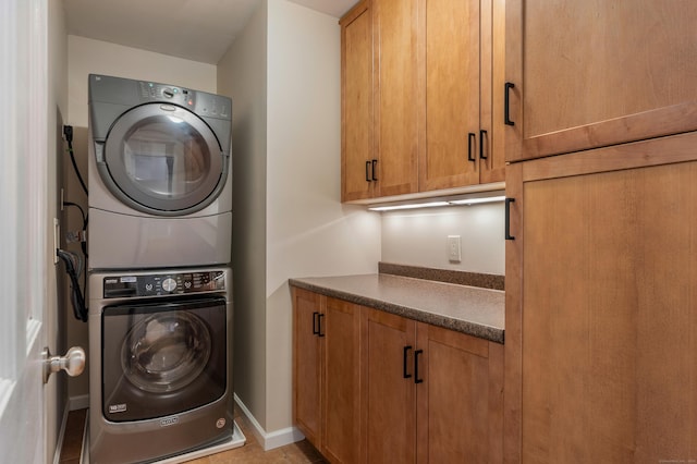 607 Tolland Stage Rd, Tolland, CT 06084 - laundry room with stacked washer / drying machine, cabinet space, and baseboards