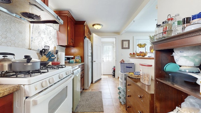 32 Lawrence Ave, Milford, CT 06460 - kitchen with white appliances, under cabinet range hood, light tile patterned flooring, and light countertops