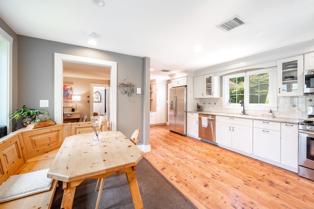 23 Goodsell Hill Rd, Redding, CT 06896 - kitchen with appliances with stainless steel finishes, light wood finished floors, backsplash, white cabinets, and recessed lighting