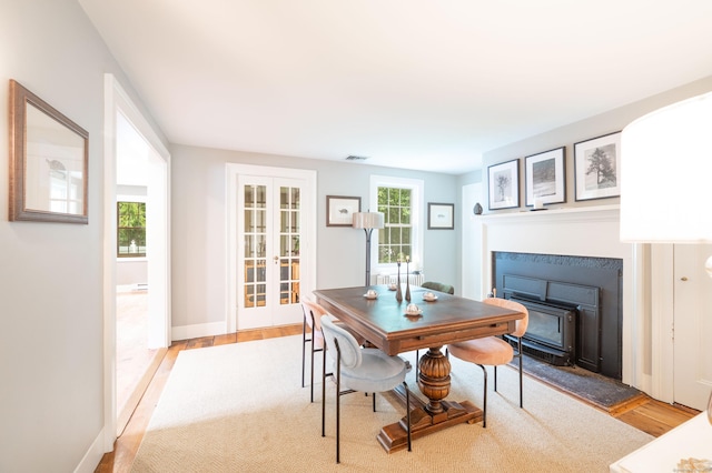 23 Goodsell Hill Rd, Redding, CT 06896 - dining space featuring french doors, a glass covered fireplace, and light wood-type flooring