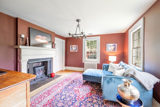 23 Goodsell Hill Rd, Redding, CT 06896 - living area with radiator heating unit, a chandelier, a fireplace with flush hearth, and wood finished floors
