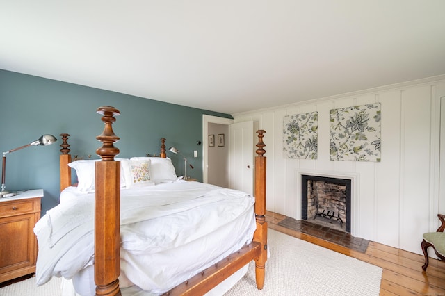 23 Goodsell Hill Rd, Redding, CT 06896 - bedroom with light wood-style floors, a fireplace, and a decorative wall