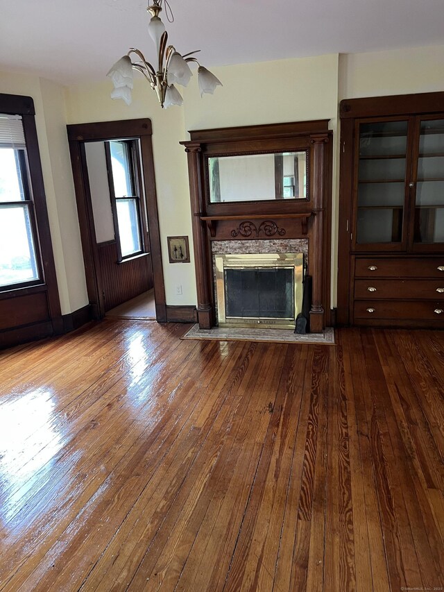 868 Elm St, New Haven, CT 06511 - unfurnished living room featuring dark wood finished floors, a stone fireplace, a chandelier, and baseboards