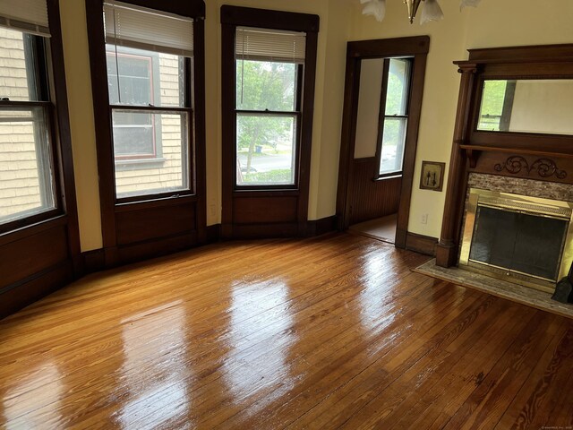 868 Elm St, New Haven, CT 06511 - unfurnished living room featuring hardwood / wood-style floors, a brick fireplace, healthy amount of natural light, and baseboards