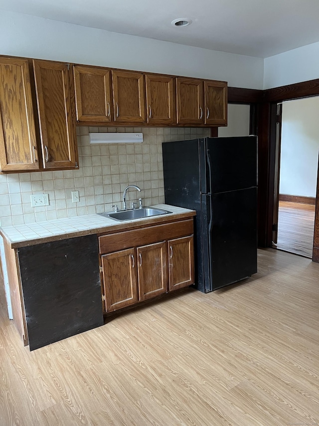 868 Elm St, New Haven, CT 06511 - kitchen with freestanding refrigerator, tile countertops, a sink, light wood-style floors, and backsplash
