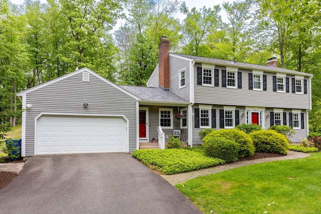 16 Darley Dr, Hamden, CT 06518 - colonial inspired home featuring a chimney, driveway, a garage, view of wooded area, and a front lawn