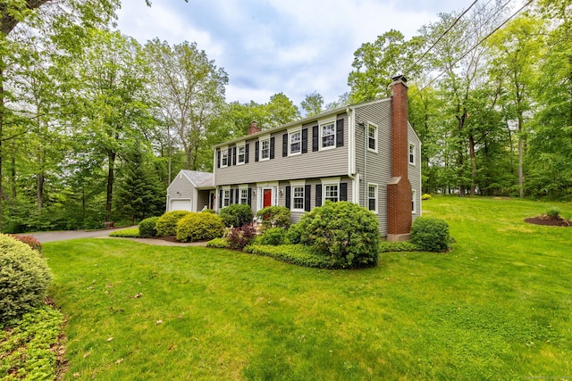 16 Darley Dr, Hamden, CT 06518 - colonial-style house featuring a chimney, an attached garage, a front yard, asphalt driveway, and view of wooded area