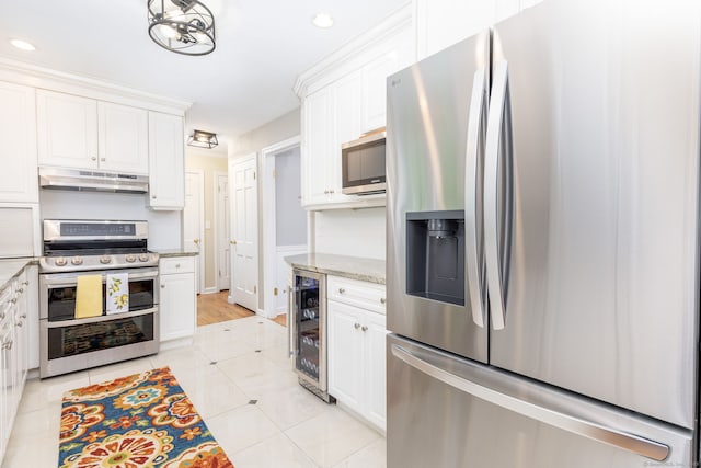 16 Darley Dr, Hamden, CT 06518 - kitchen with stainless steel appliances, under cabinet range hood, beverage cooler, white cabinets, and recessed lighting