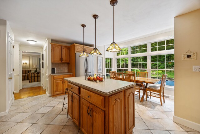 50 Stonehedge Ln S, Guilford, CT 06437 - kitchen featuring freestanding refrigerator, light tile patterned flooring, baseboards, and crown molding