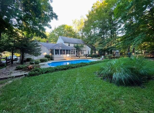 50 Stonehedge Ln S, Guilford, CT 06437 - back of property featuring a sunroom, a yard, and an outdoor pool