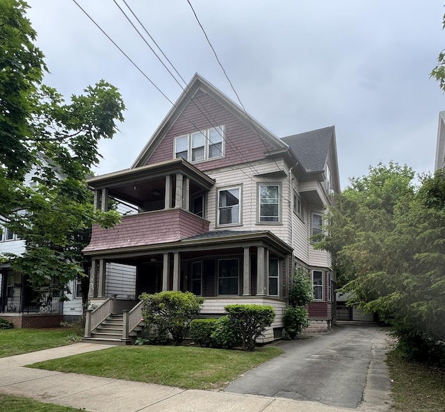 96 Hubinger St, New Haven, CT 06511 - view of front of house with a balcony, a porch, roof with shingles, and a front lawn