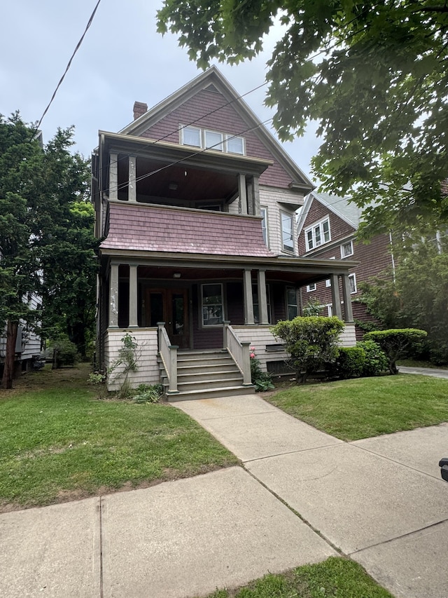 96 Hubinger St, New Haven, CT 06511 - view of front facade with a balcony, a porch, a front yard, and a chimney