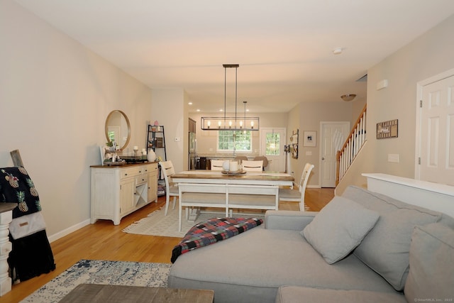23 Riverview Ct Unit 23, Brookfield, CT 06804 - living room featuring stairway, light wood-style flooring, baseboards, and a chandelier