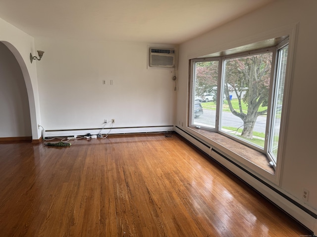 129 Monroe St, East Hartford, CT 06118 - unfurnished room with a baseboard radiator, an AC wall unit, wood finished floors, arched walkways, and baseboard heating