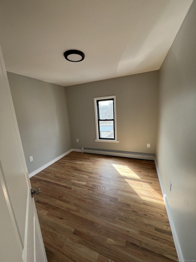 49 Hill St, Waterbury, CT 06704 - empty room with a baseboard heating unit, dark wood-style floors, and baseboards