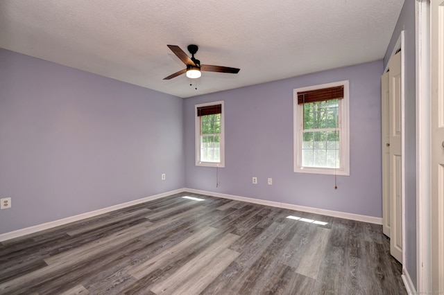 37 White Tail Ln Unit 37, Wallingford, CT 06492 - unfurnished bedroom with multiple windows, dark wood-style floors, a textured ceiling, and baseboards