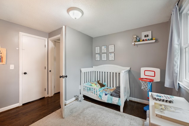 29 Carson Ave, Wethersfield, CT 06109 - bedroom featuring wood finished floors, baseboards, a crib, and a textured ceiling