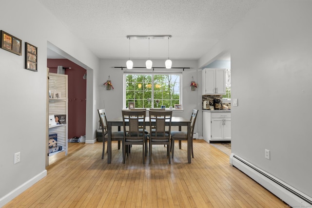 167 Santa Maria Dr, Torrington, CT 06790 - dining area with a baseboard radiator, a textured ceiling, light wood-type flooring, and baseboards