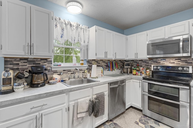 167 Santa Maria Dr, Torrington, CT 06790 - kitchen featuring stainless steel appliances, a sink, light countertops, a textured ceiling, and white cabinetry