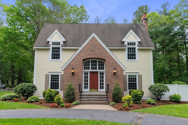 27 Chiltern St, Farmington, CT 06032 - view of front facade with a chimney and brick siding