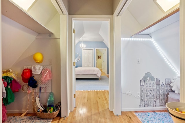 27 Chiltern St, Farmington, CT 06032 - corridor featuring wood finished floors, vaulted ceiling, and a chandelier