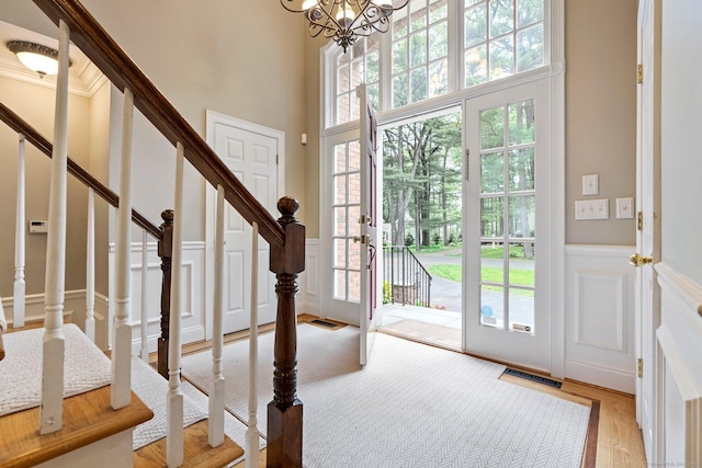 27 Chiltern St, Farmington, CT 06032 - entryway featuring a decorative wall, wainscoting, stairway, a chandelier, and wood finished floors