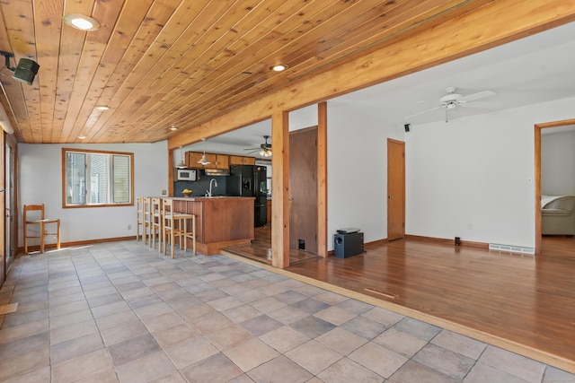 309 Marlborough Ter, Fairfield, CT 06825 - kitchen featuring ceiling fan, black fridge with ice dispenser, open floor plan, white microwave, and recessed lighting