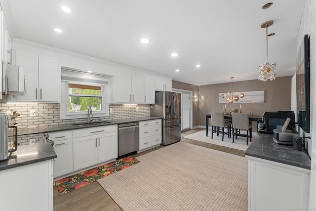 6 Meadow Dr, Waterford, CT 06385 - kitchen featuring appliances with stainless steel finishes, a sink, backsplash, light wood finished floors, and white cabinets