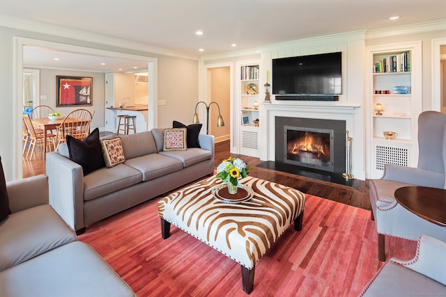 145 Seir Hill Rd, Wilton, CT 06897 - living area featuring a large fireplace, wood finished floors, crown molding, built in features, and recessed lighting
