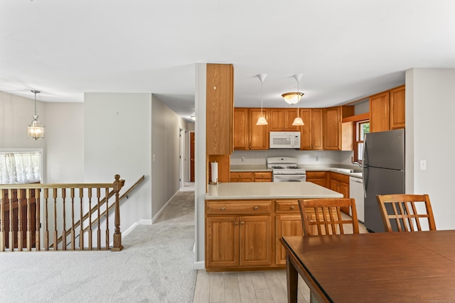 5 Settlers Ln, Newtown, CT 06482 - kitchen featuring white appliances, brown cabinets, baseboards, and decorative light fixtures
