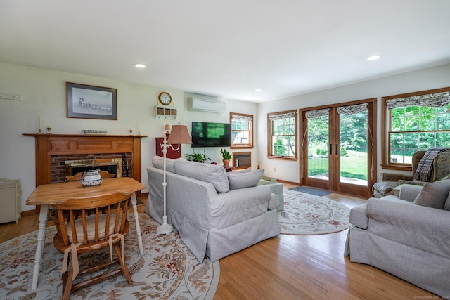 16 Botsford Rd, Kent, CT 06757 - living area with a wall unit AC, french doors, wood finished floors, recessed lighting, and a brick fireplace