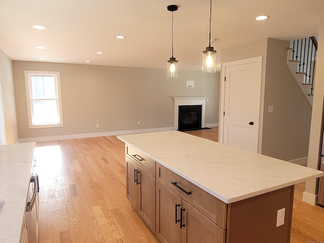 82 Ladd Rd, Tolland, CT 06084 - kitchen featuring open floor plan, light wood-style flooring, a fireplace with flush hearth, recessed lighting, and hanging light fixtures