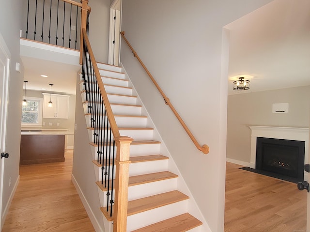 82 Ladd Rd, Tolland, CT 06084 - staircase featuring wood finished floors and a fireplace with flush hearth