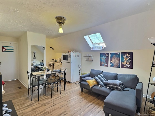 1 N Taylor Ave, Norwalk, CT 06854 - living room featuring a skylight, light wood-type flooring, a textured ceiling, and vaulted ceiling