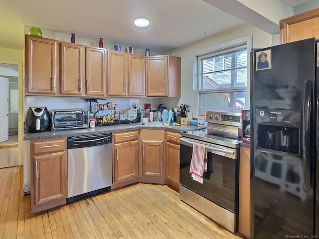 1 N Taylor Ave, Norwalk, CT 06854 - kitchen featuring stainless steel appliances, dark countertops, light wood-style floors, and brown cabinetry