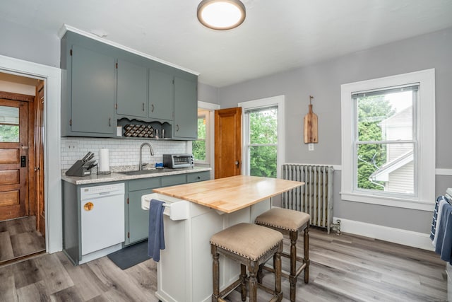 5 Seymour Ave, West Hartford, CT 06119 - kitchen with radiator heating unit, white dishwasher, light wood-style floors, decorative backsplash, and a kitchen island