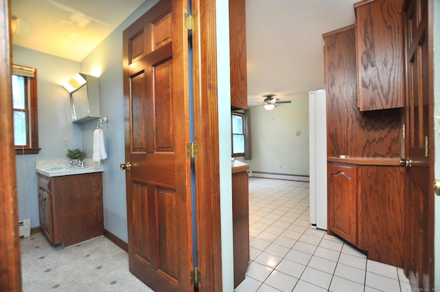 24 Jennifer Rd, Bristol, CT 06010 - corridor with a baseboard radiator, a sink, light tile patterned floors, and baseboards