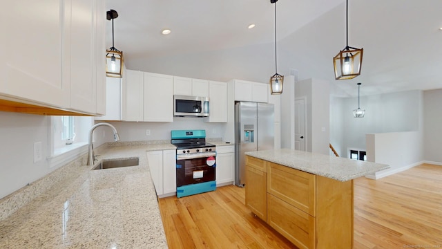 25 First Ave, Enfield, CT 06082 - kitchen featuring stainless steel appliances, a sink, a center island, light wood-style floors, and light stone counters