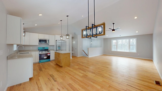 25 First Ave, Enfield, CT 06082 - kitchen with appliances with stainless steel finishes, a sink, a ceiling fan, vaulted ceiling, and a kitchen island