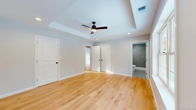 25 First Ave, Enfield, CT 06082 - unfurnished bedroom with a tray ceiling, light wood-style floors, ensuite bath, recessed lighting, and baseboards