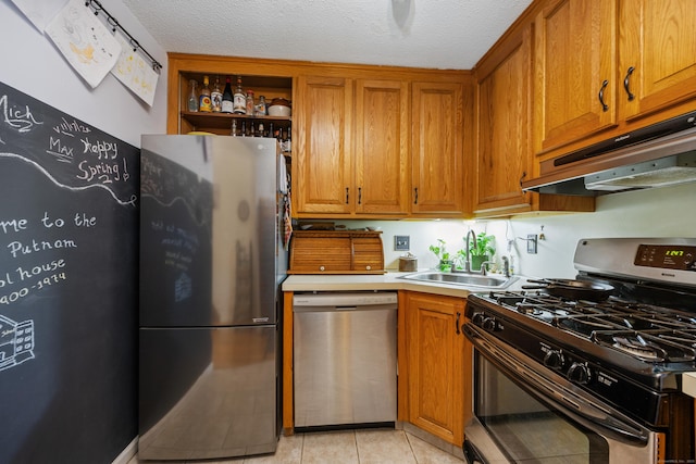 58 Woodley Ct Unit 14, Meriden, CT 06450 - kitchen featuring appliances with stainless steel finishes, a sink, under cabinet range hood, brown cabinetry, and light countertops