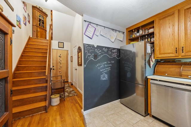 58 Woodley Ct Unit 14, Meriden, CT 06450 - kitchen with stainless steel appliances, open shelves, light countertops, brown cabinets, and light wood-type flooring