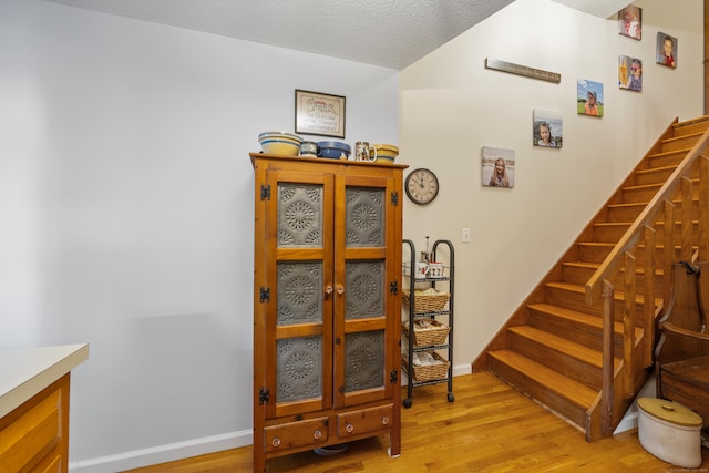 58 Woodley Ct Unit 14, Meriden, CT 06450 - stairs with wood finished floors, a textured ceiling, and baseboards