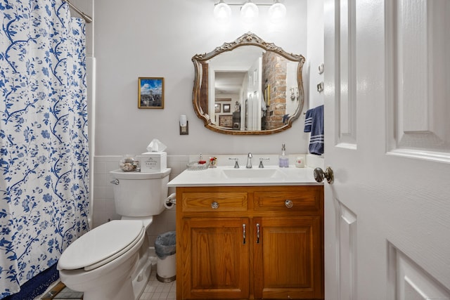 58 Woodley Ct Unit 14, Meriden, CT 06450 - bathroom featuring vanity, toilet, tile walls, a wainscoted wall, and tile patterned floors